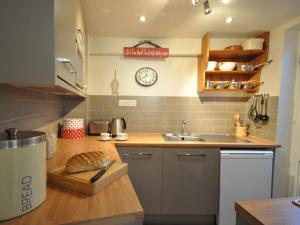 a kitchen with a sink and a clock on the wall at 1 Bed in Appledore MASTR in Appledore