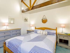 um quarto com uma cama azul e branca com 2 candeeiros em 2 Bed in Holsworthy GFOXG em Sutcombe