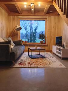 uma sala de estar com um sofá e uma mesa em Lodges Clara Vallis em Clairvaux-les-Lacs