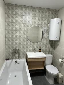 uma casa de banho com uma banheira, um WC e um lavatório. em The Cube em Kremenchuk