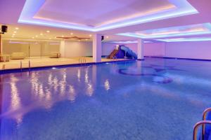 a swimming pool with a slide in a building at The Sentra Manado in Manado