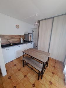 eine Küche mit einem Holztisch mit einer Bank in der Unterkunft T1 tout confort in Saint-Denis