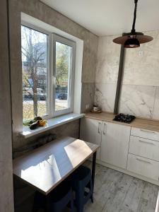 uma cozinha com uma mesa de madeira e uma janela em The Cube em Kremenchuk