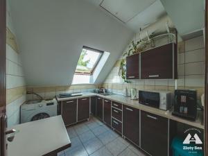 a small kitchen with a washing machine and a window at Zloty Sen in Stronie Śląskie