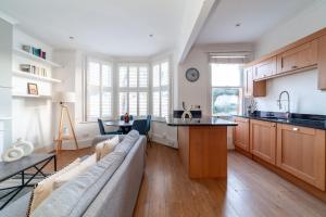 sala de estar con sofá y cocina en The Richmond Apartments, en Richmond upon Thames