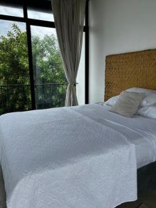 sypialnia z białym łóżkiem i oknem w obiekcie Paraíso Escondido en Punta Barandua w mieście San Pedro