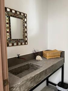 W łazience znajduje się kamienna umywalka i lustro. w obiekcie Paraíso Escondido en Punta Barandua w mieście San Pedro
