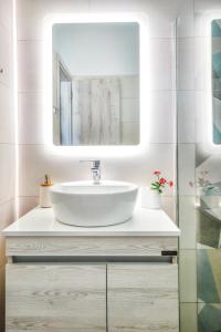 W łazience znajduje się umywalka i lustro. w obiekcie Catherine Blue Suites - 4 minutes off the Beach w mieście Poros