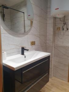 a bathroom with a white sink and a mirror at Apartament Ogrodzieniec in Ogrodzieniec