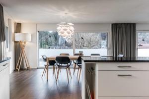 Apartment Alpeglöggli - GriwaRent AG في إنترلاكن: مطبخ وغرفة طعام مع طاولة وكراسي