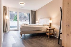 sypialnia z łóżkiem i dużym oknem w obiekcie Apartment Alpeglöggli - GriwaRent AG w mieście Interlaken
