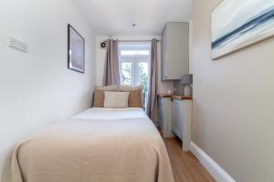 Habitación pequeña con cama y ventana en The Richmond Apartments, en Richmond upon Thames