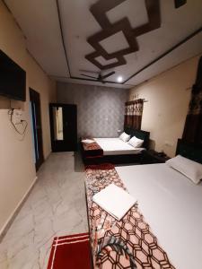 瓦拉納西的住宿－Raghuvanshi Paying Guest House，一间设有两张床和一张沙发的房间