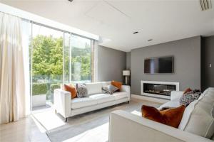 a living room with white furniture and a large window at Lux, Large Central Mayfair Location Flat in London