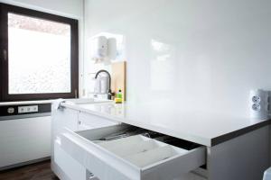 a white kitchen with a sink and a window at Work & Stay Apartment Goch in Goch