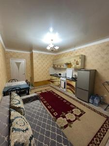 a living room with a couch and a refrigerator at Уютная квартира комфорт класса111 in Astana