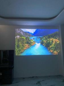 una tv appesa a un muro con un fiume di T~ONE HOSTEL a Cái Răng