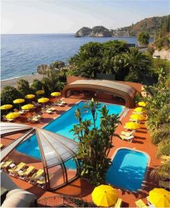 an aerial view of a resort with a pool and chairs and umbrellas at A Casitta Luxury Apartments in Taormina