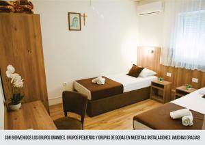 a hotel room with two beds and a table at Mica Medjugorje in Međugorje