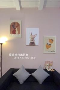een woonkamer met een bank en foto's aan de muur bij Love The Countryside B&B in Hualien