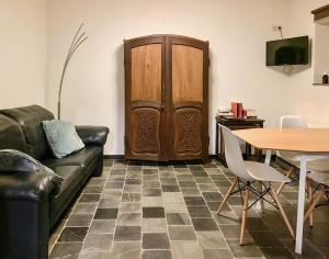 ein Wohnzimmer mit einem Sofa, einem Tisch und einer Holztür in der Unterkunft Lovely apartment in Voeren in Voeren