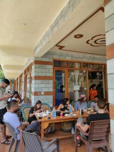 eine Gruppe von Menschen, die an Tischen in einem Restaurant sitzen in der Unterkunft NEW SAMY CAFE AND HOMESTAY in Kasol