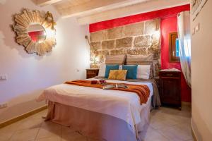 a bedroom with a large bed with a red wall at La Casa di Zaira in Alghero