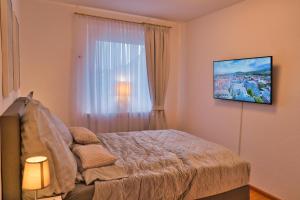 a bedroom with a bed and a television on the wall at Heimat Goslar Apartments "Zum Marktplatz" in Goslar