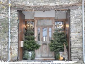 una puerta de entrada de una casa con dos árboles de Navidad en Villa with hot tub and sauna, en Bièvre