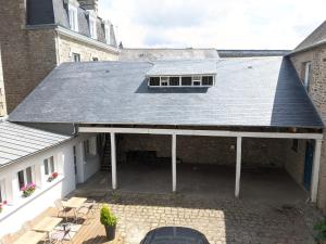 une vue extérieure sur une maison avec un toit dans l'établissement Hôtel Océan Dinan, à Dinan