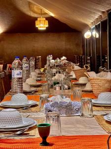 a long table with plates and dishes on it at Desert Sahara Luxury Camp in Merzouga