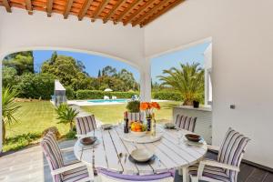 a white dining room with a table and chairs at Villa Figueiras by Villa Plus in Lagoa