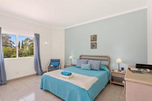 a bedroom with a blue bed and a window at Villa Figueiras by Villa Plus in Lagoa