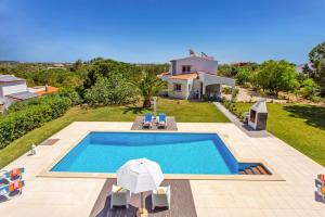a villa with a swimming pool and a house at Villa Figueiras by Villa Plus in Lagoa