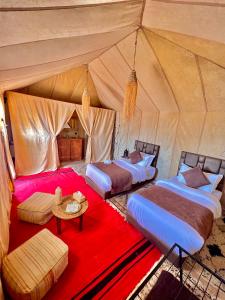 a bedroom with three beds in a tent at Desert Sahara Luxury Camp in Merzouga