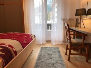 a bedroom with a bed and a desk and a chair at appartamento SELVA VAL GARDENA in Plan