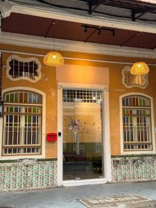 a store front with two windows and a table at Swing & Pillows @ Muntri in George Town