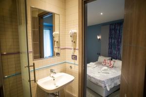 Cola Di Rienzo Suite Guest House في روما: حمام مع حوض وسرير صغير