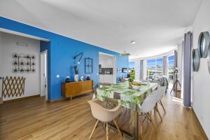 uma sala de jantar com uma parede azul e uma mesa e cadeiras em Villa Casa Duarte by Villa Plus nos Olhos de Água