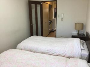 Een bed of bedden in een kamer bij Business Inn Grandeur Fuchu