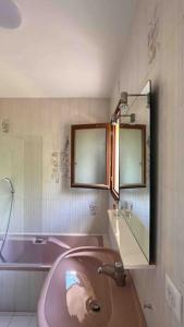 La salle de bains est pourvue d'un lavabo rose et d'une baignoire. dans l'établissement Villa Horizon/Vue mer/Plages/WIFI/CLIM, à Carqueiranne