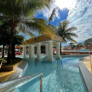 a swimming pool with a gazebo and palm trees at Lacqua DiRoma III com roupa de cama in Caldas Novas