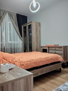 um quarto com uma cama grande e um cobertor laranja em Ebruli 136 em Avcılar