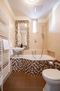 uma casa de banho com uma banheira, um WC e um lavatório. em Liget Apartment em Budapeste