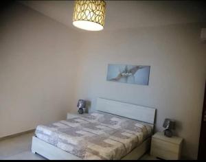een slaapkamer met een bed in een kamer met een licht bij Stella Marina in Giardini Naxos