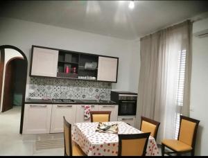 een keuken met een tafel en stoelen en een keuken met een aanrecht bij Stella Marina in Giardini Naxos