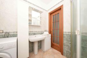 La salle de bains blanche est pourvue d'un lavabo et d'un miroir. dans l'établissement Floriana Apartment, à Desenzano del Garda
