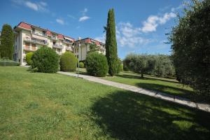 un bâtiment dans un parc avec des arbres et une pelouse dans l'établissement Floriana Apartment, à Desenzano del Garda