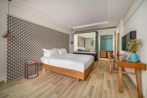een slaapkamer met een bed en een bureau bij Brilliant Majestic Hotel in Da Nang