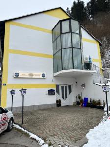a white and yellow building with a balcony at Privat zimmer ERONN VEİTSCH in Veitsch